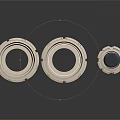 Industrial Metal Ring Components Two Flat Placed And One Upright With Black Base