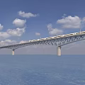 Modern Bridge With High Speed Train Crossing Over Blue Water and Sky