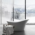 White Bathtub with Large Windows Overlooking Snowy Mountains Trees and Side Cart Holding Towels