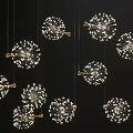 Multiple Dandelion Shaped Chandeliers With Gold Accents And Bright White Lights Against Black Background