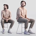 Two Men Sitting on White Stools Wearing Beige T-Shirts and Khaki Pants