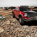 Red Pickup Truck On Off Road Terrain With Roof Lights