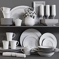 Modern White Dinnerware Set with Stacked Plates Cups Wine Glasses and Green Plant Decoration