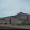 Modern Office Building With Chinese Style Roof White Exterior Large Windows Parking And Green Plants