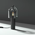 Modern Table Lamp With Black Base Transparent Glass Shade And Illuminated Bulb