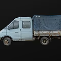 Old White Van With Blue Tarp Covered Cargo Bed And Worn Tires