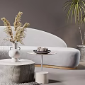 Gray Curved Sofa And Round Stone Coffee Table With Dried Flowers Woven Rug Green Plants