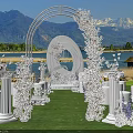 Scenic Garden Landscape With White Floral Archway Circular Ornament Pillars Lawn Lake And Mountain Backdrop