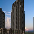 Modern High Rise Office Building With Glass Facade And Illuminated Windows At Sunset