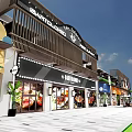 Modern Commercial Street With Colorful Storefronts Awnings Outdoor Seating And Paved Plaza