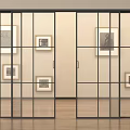 Black Framed Glass Sliding Doors In Room With Framed Artworks And Wooden Floor