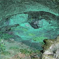 Natural Cave Landscape With Rocky Ceiling Green Vegetation And Earthy Ground