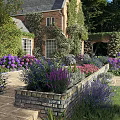 Garden Landscape Design With Brick House Climbing Vines Colorful Flowers And Arched Structure