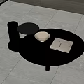 Modern Round Black Coffee Table With Glass Top Bowl Book And Cup In Living Room