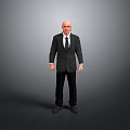 Bald Man in Black Suit and Tie Standing Against Gray Background