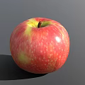 Juicy Fresh Ripe Red Apple With Yellow Streaks Speckled Surface On Gray Background