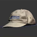 Beige Boston Cap With Blue Lettering Placed On Soft Blue Mat