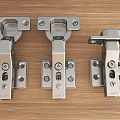 Three Stainless Steel Hinges Displayed On Wooden Surface With Metal Construction