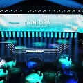 Hisense Event Stage With Blue Lighting Projection And Round Tables Setup