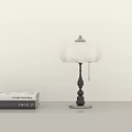 Modern Table Lamp With White Lampshade Black Post And Silver Base On Table Near Books