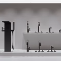 Various Modern Faucet Models With Large Black Faucet Displayed On White Countertop In Showroom