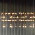 Illuminated Golden Chandeliers with Round Bulbs and Metal Bars Hanging on Dark Vertical Striped Background
