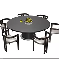 Modern Round Black Dining Table with Six Wooden Frame White Cushion Chairs and Fruit Bowl