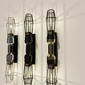 Three Modern Wall Lamps With Cage Design And Shadow Effect On White Wall