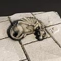 Intricately Carved Dragon Sculpture Lying On Gray Stone Tiles Surface