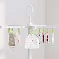 White Tripod Clothes Drying Rack With Baby Clothes In Indoor Home Setting