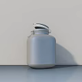 Ceramic Jar With Silver Metal Lid On Gray Countertop Against White Background