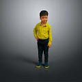 Young Boy In Yellow Shirt Dark Pants And Green Shoes Standing Against Gray Background