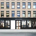 James & Company Storefront Facade Of Brick Building With Large Windows And Mannequin Displays