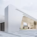Modern White Entrance Gate With Sleek Curved Design And Spacious Stone Paved Area