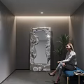 Irregular Shaped Silver Mirror in Modern Interior with Green Plant and Seated Woman
