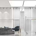 Modern Minimalist Clothing Store Interior With White Walls Clothing Racks And Sofa In Open Space