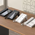 Four Black And White Landline Telephones Placed On Wooden Table For Office Use