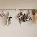 Various Kitchen Aprons And Towels Hanging On Wooden Hooks Against Beige Wall