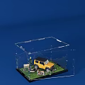 Transparent Acrylic Box With Yellow SUV Model Grass Sign Plants Figures On Blue Background