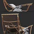 Comfortable Rattan Lounge Chair With Gray And White Pillows And Plaid Blanket