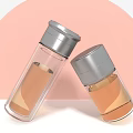 Transparent Glass Cups With Silver Lids And Light Brown Liquid In Pink Gray Background