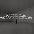 Large Hanging Art Installation with White Geometric Shapes Suspended by Thin Wires in Spacious Gallery