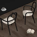 Single Chair With Black Frame Beige Cushion Dark Wooden Floor Coffee Cup And Open Book