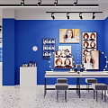 Blue Themed Studio Interior Design With Framed Portraits Lighted Mirror White Cabinets And Orange Accents