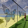 Scenic Garden Landscape With Butterfly Patterned Fence Girl On Green Lawn Under Blue Sky