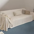 Beige Slipcovered Sectional Sofa With Cushions Blanket And Blue Rug On Wooden Floor