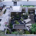 Modern Urban Garden Landscape With Serene Pond Lush Greenery Paved Walkways And Seating Areas