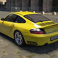 Yellow Porsche Sports Car Parked On Cobblestone Road With Trees And Buildings In Background
