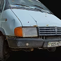 Old White Van With Blue Tarp Covered Cargo Bed And Worn Tires