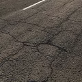 Damaged Road Infrastructure With Cracks And White Lane Line On Asphalt Surface